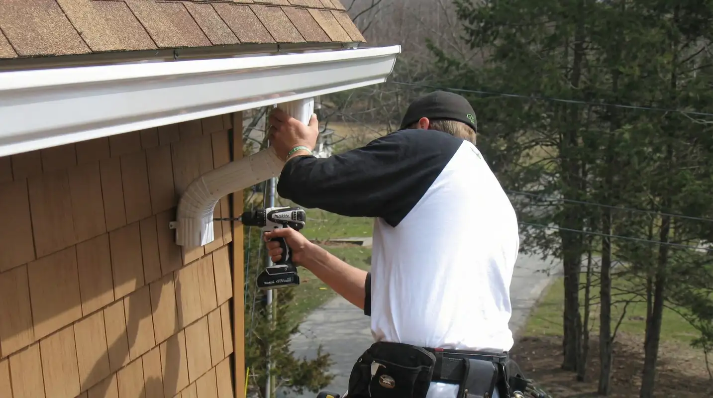 Professional contractor installing tan vinyl siding panels on a residential home exterior in Richmond, VA